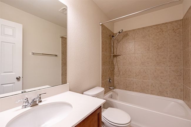 Full bath featuring vanity, shower / tub combination, and a textured wall | Image 22