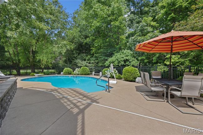 View of pool featuring a patio and view of wooded area | Image 67