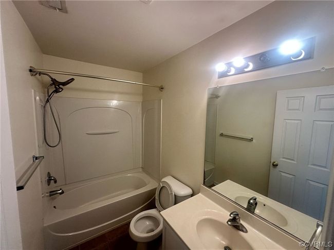 Full bathroom featuring large vanity, bathing tub / shower combination, and toilet | Image 10