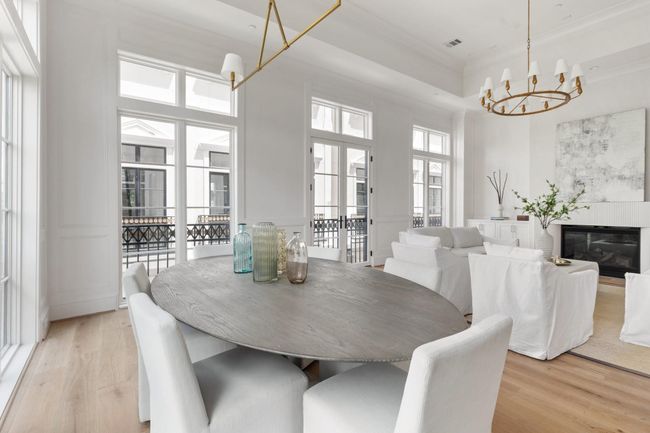 Bathed in natural light, the dining area showcases rich hardwoods and curated designer lighting—perfect for intimate dinners or festive gatherings. | Image 8