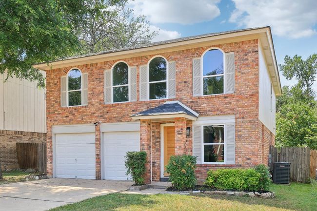View of front of property with a garage, brick siding, concrete driveway, and central air condition unit | Image 27