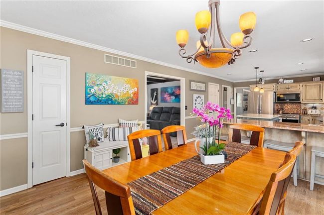 Dining room featuring crown molding, a notable chandelier, and light wood-type flooring | Image 17