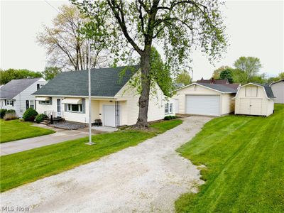 View of front of property with a garage, a storage shed, and a front yard | Image 2