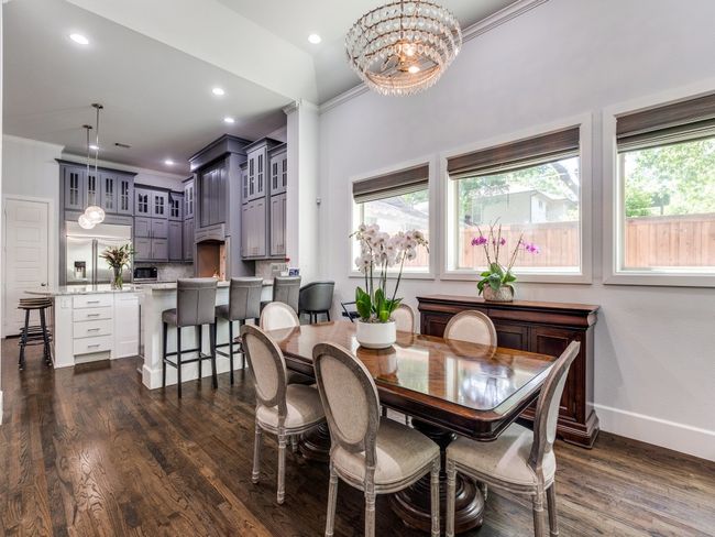Dining area with baseboards, dark wood-type flooring, a chandelier, ornamental molding, and recessed lighting | Image 8
