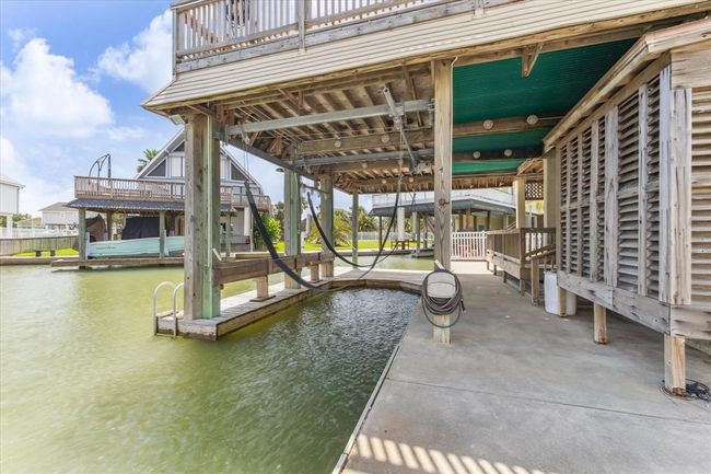 This photo shows a waterfront property with a covered boat slip and dock. | Image 33