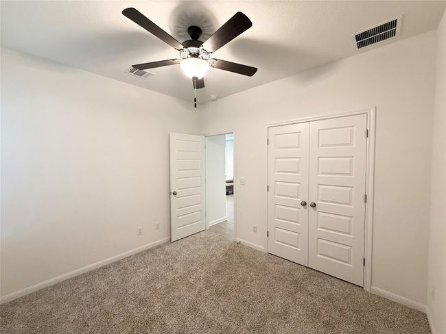 Unfurnished bedroom featuring carpet flooring, baseboards, a closet, and ceiling fan | Image 21