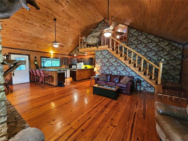 View from the Fireplace of the Living area, Kitchen and the Finished Rustic Wood Staircase | Image 8