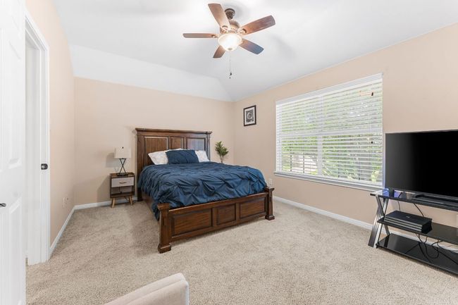 Bedroom featuring carpet flooring, baseboards, lofted ceiling, and a ceiling fan | Image 25