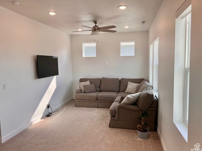 Carpeted living room with a textured ceiling and ceiling fan | Image 13