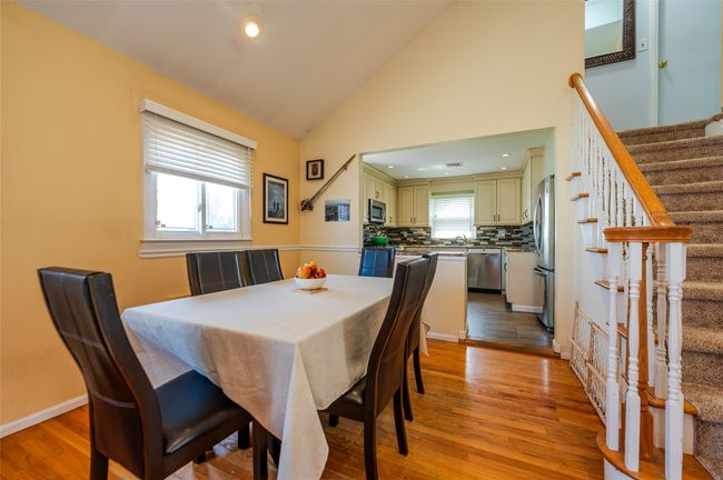 Dining room featuring a healthy amount of sunlight, high vaulted ceiling, stairway, and light wood finished floors | Image 6