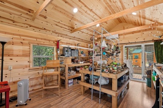 A crafters dream featuring shelving and a large work table | Image 17