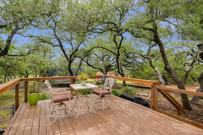 Shaded by mature oaks, this outdoor area provides a peaceful and private setting. | Image 26