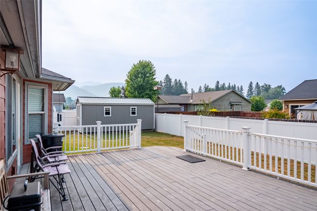 Wooden deck with a yard, a fenced backyard, an outdoor structure, and a mountain view | Image 31
