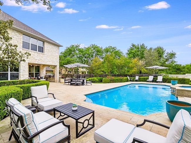 View of swimming pool featuring a patio, an outdoor living space, fence, and a pool with connected hot tub | Image 24