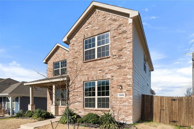 Traditional-style house featuring brick siding and fence | Image 21