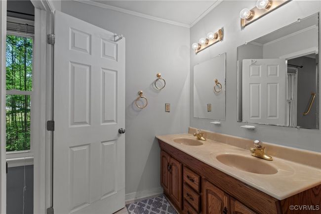 Bathroom with baseboards, ornamental molding, a sink, and double vanity | Image 21