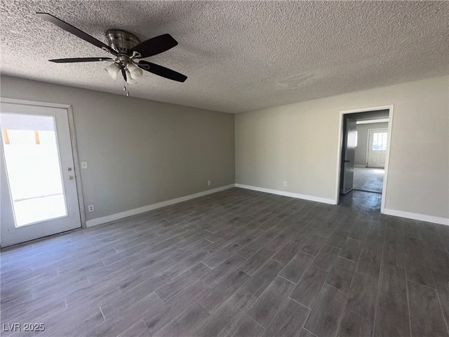 Unfurnished room featuring a ceiling fan, dark wood-style floors, baseboards, and a textured ceiling | Image 7