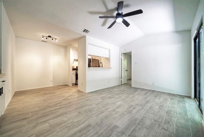 Unfurnished living room featuring a ceiling fan, light wood finished floors, and lofted ceiling | Image 4