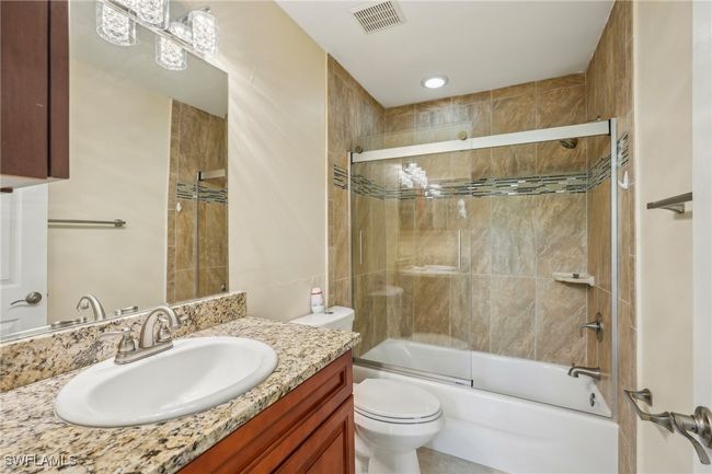 Bathroom featuring shower / bath combination with glass door and vanity | Image 27