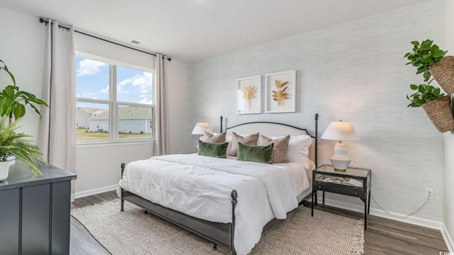 Bedroom featuring baseboards, an accent wall, wood finished floors, and wallpapered walls | Image 14