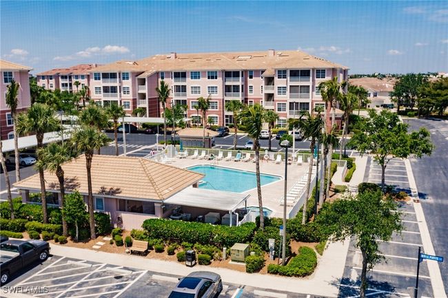 View of property with uncovered parking and a community pool | Image 28