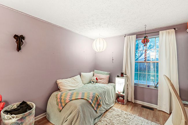 bedroom with wood finished floors and a textured ceiling | Image 15