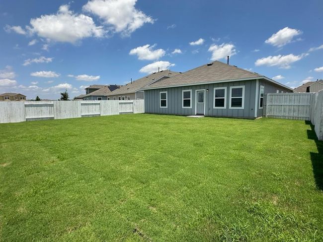 Back of house with board and batten siding and roof with shingles | Image 16