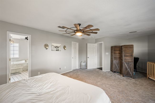 Bedroom featuring carpet, visible vents, baseboards, and ensuite bathroom | Image 15