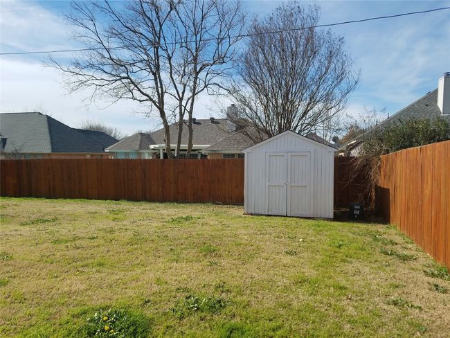 Fenced backyard featuring a storage shed | Image 14