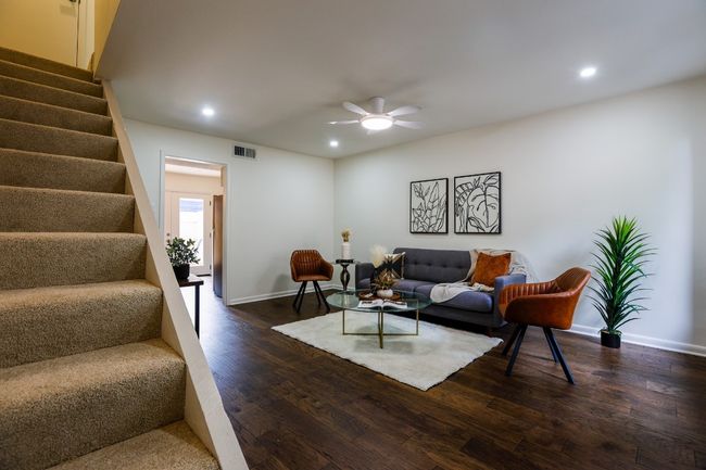 Living room with stairway, recessed lighting, a ceiling fan, and engineered hardwood finished floors. | Image 4