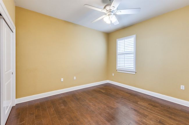 Unfurnished bedroom featuring a ceiling fan, dark wood-type flooring, a closet, and baseboards | Image 16