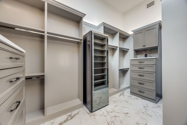 Walk in closet featuring light marble finish flooring | Image 15