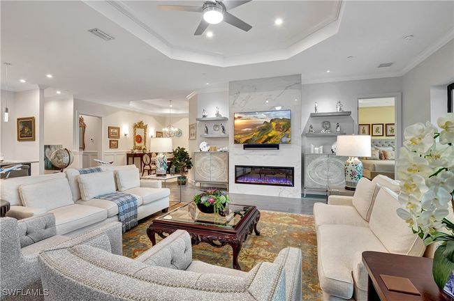 Features a premium linear remote controlled controlled fireplace on a custom tiled wall, tray ceiling, and crown molding | Image 14