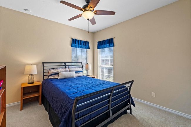 Bedroom featuring a ceiling fan, baseboards, and carpet floors | Image 31