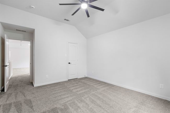 Unfurnished bedroom with lofted ceiling, visible vents, carpet floors, and baseboards | Image 31