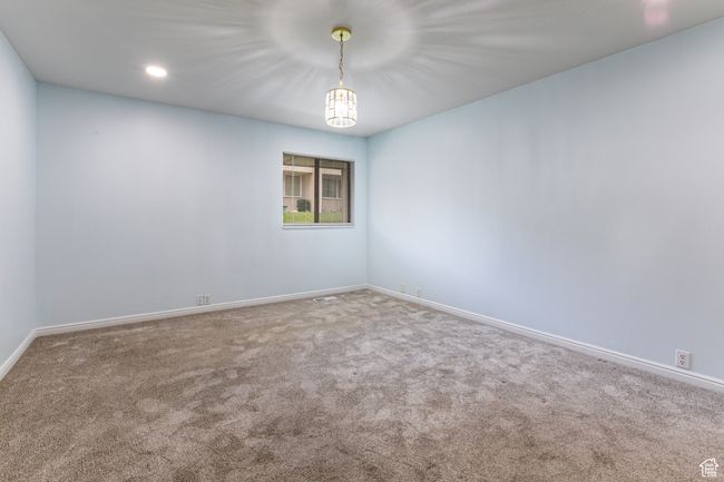 Carpeted empty room with baseboards, recessed lighting, and a chandelier | Image 22