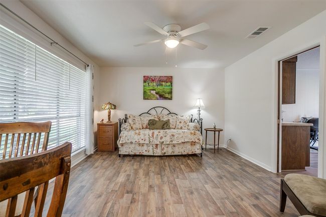 Bedroom with wood finished floors and ceiling fan | Image 10
