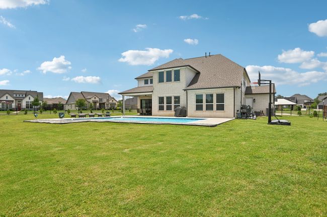 Back of property with roof with shingles, an outdoor pool, a fenced backyard, a patio area, and brick siding | Image 39