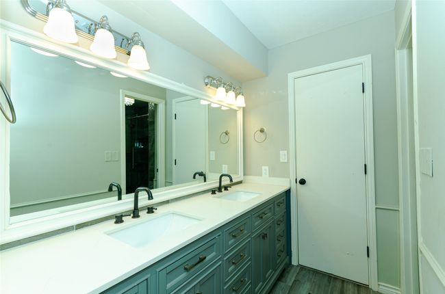 Full bathroom featuring double vanity, a stall shower, and dark wood-type flooring | Image 14