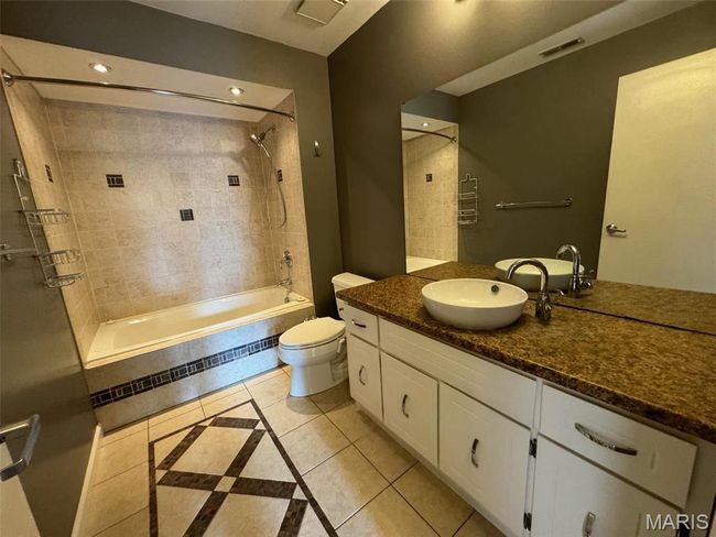 Full hall bathroom featuring tile patterned flooring, vanity, toilet, and tiled shower / bath | Image 26