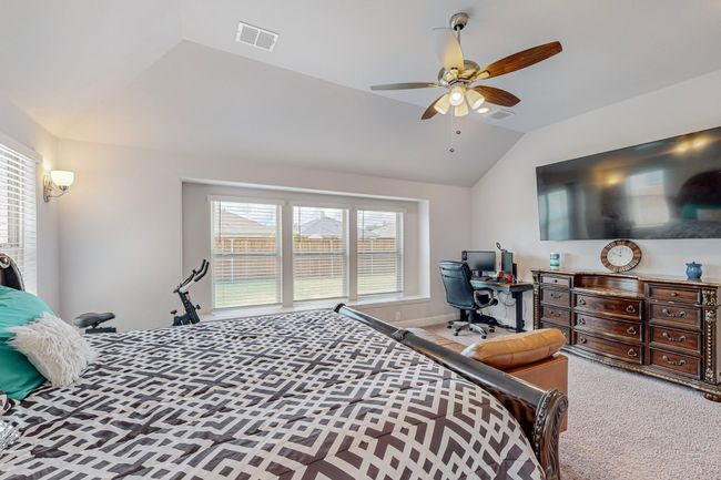 Bedroom with visible vents, a ceiling fan, carpet floors, and vaulted ceiling | Image 15