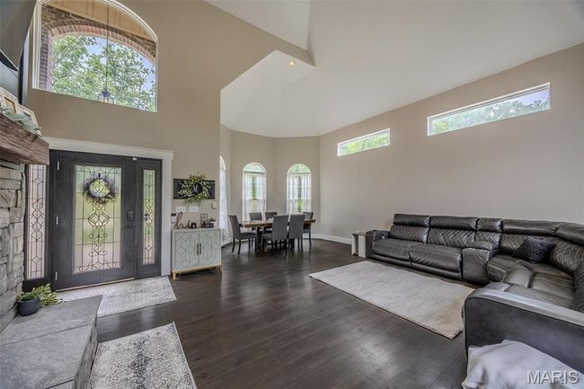 Living room with a towering ceiling and dark wood-type flooring | Image 13