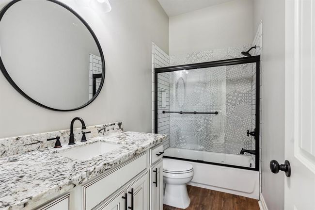 En-suite bathroom to secondary downstairs bedroom features beautiful tile shower wall. | Image 26
