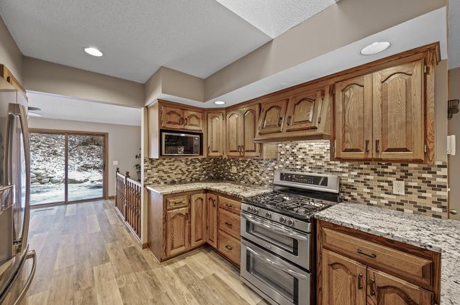 The kitchen provides a nice, functional work triangle - Just by the railing, there's a peek at one of the sets of stairs that lead to the lower level | Image 20