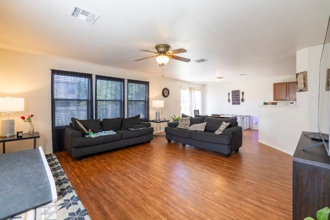 Living area with ceiling fan and wood finished floors | Image 4