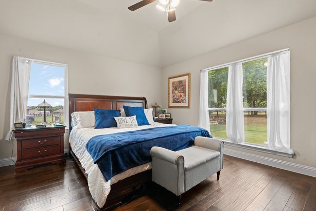 Bedroom featuring dark wood-type flooring, vaulted ceiling, and a ceiling fan | Image 16