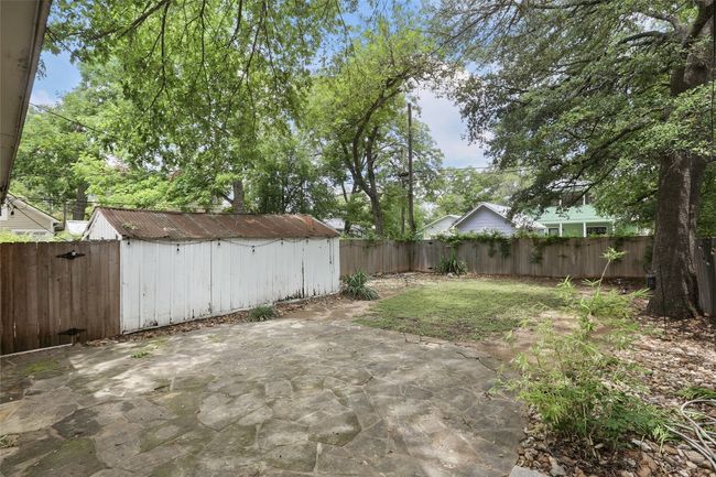 Fenced backyard with a patio area and a storage unit | Image 26