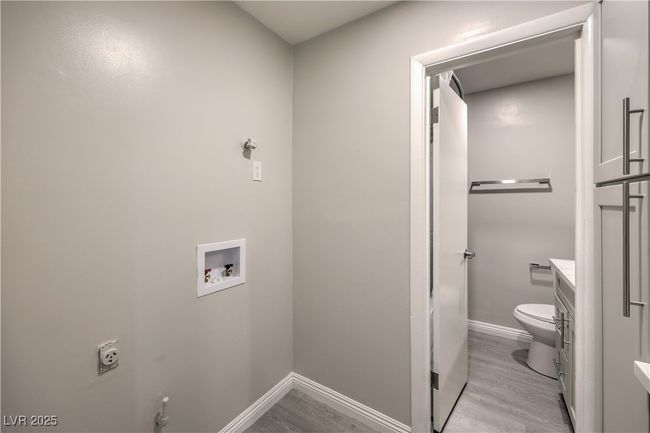 Clothes washing area featuring hookup for a washing machine, electric dryer hookup, light wood-type flooring, laundry area, and baseboards | Image 34
