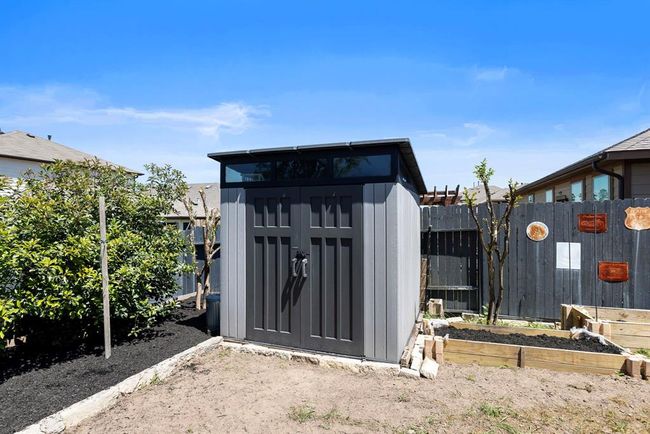 This storage shed is perfect for storing & organizing lawn equipment & tools. There is also overhead storage in the garage. The seller also added a side gate for added convenience. | Image 41