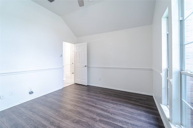 Unfurnished room featuring vaulted ceiling, dark wood finished floors, and a ceiling fan | Image 32